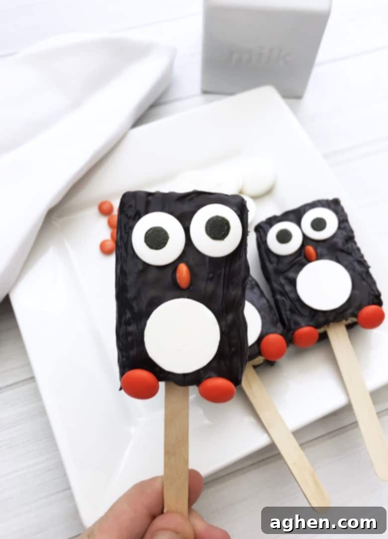 These adorable penguin Rice Krispie Treats take minutes to make using store-bought Rice Krispie Treats, candy melts, and a few candies.