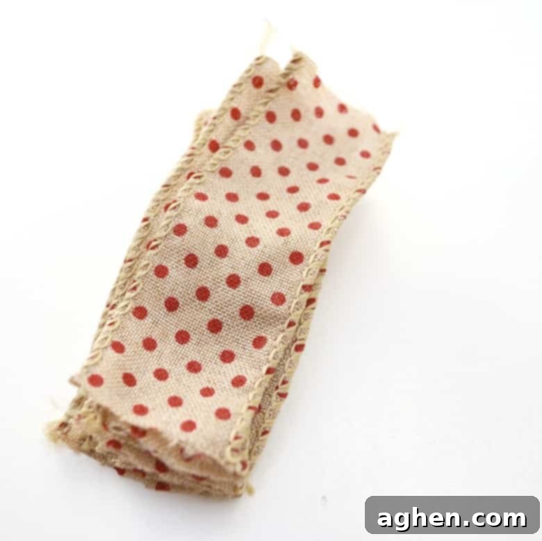 Cutting short pieces of wide burlap ribbon to begin crafting a rustic Christmas tree decoration.