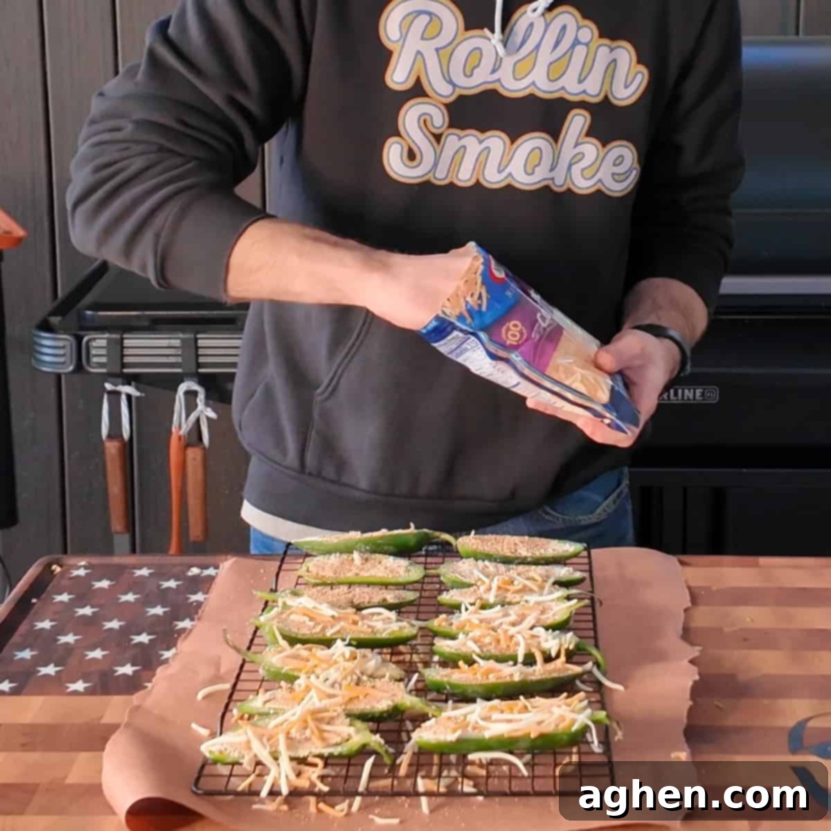 Jalapeno poppers filled and topped with cheese, arranged on a wire rack ready for the smoker