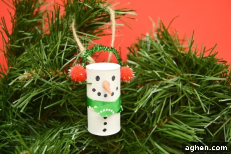 Upcycled Wine Cork Snowman Ornaments 2 Handmade wine cork snowman ornament hanging on a Christmas tree, perfect for an easy holiday craft for kids and adults