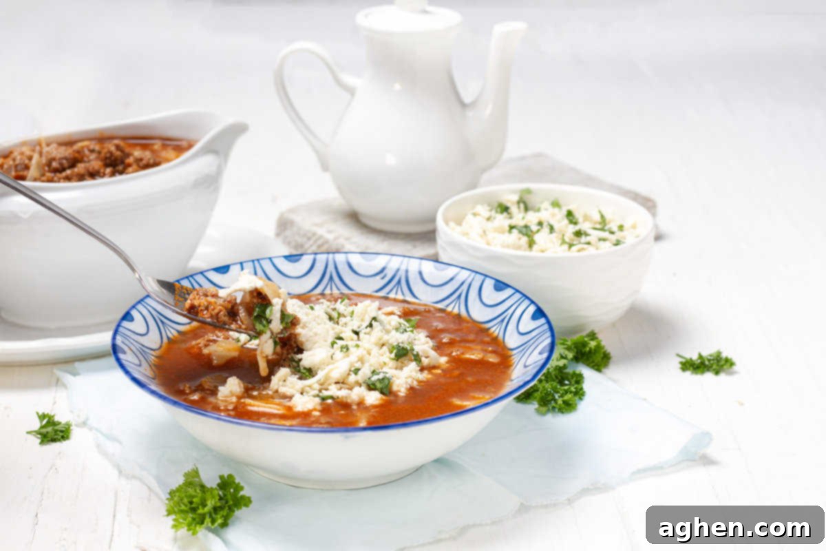 A freshly served bowl of Lasagna Soup, topped with crumbled feta, cottage cheese, and fresh parsley, ready to be enjoyed.