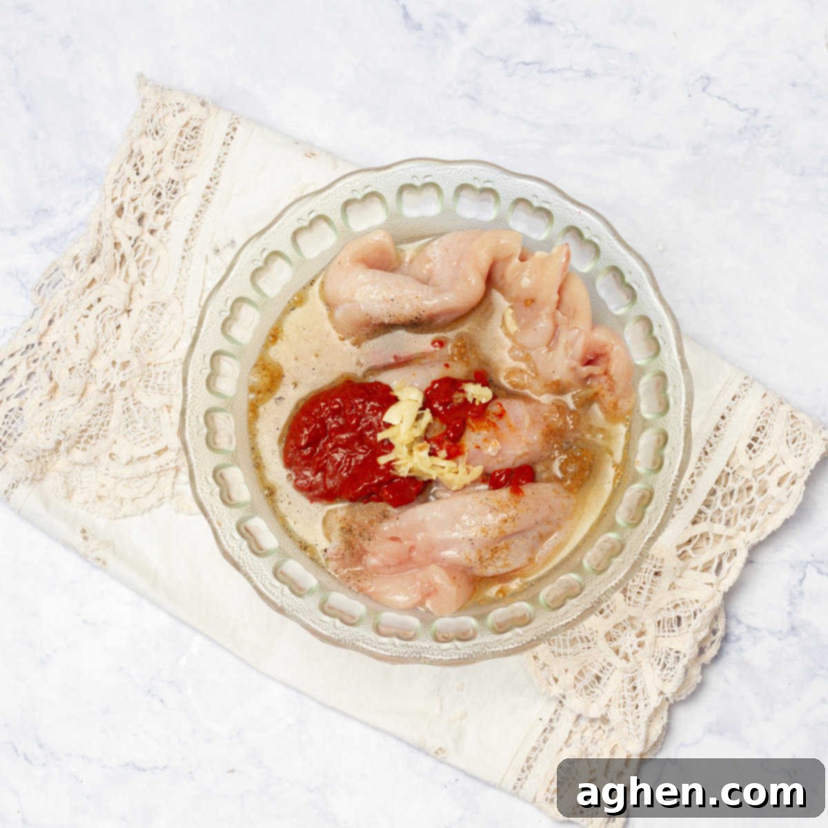 marinating chicken in a bowl with achiote paste, bitter orange juice, lime juice, ground cumin, and minced garlic