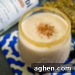 A rich and creamy, no-egg, coquito recipe made with rum and coconut milk, in a small serving glass.