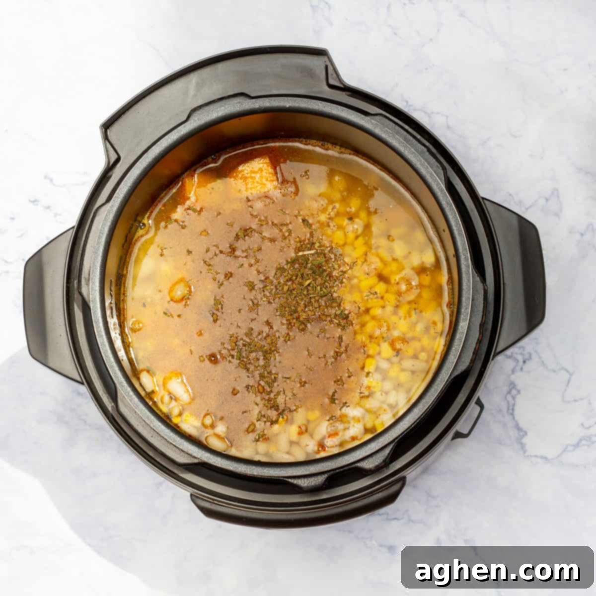 Guilt-Free Delicious Porotos Granados Soup Only 1 Weight Watchers Point 6 Vegetable or chicken broth being poured into the Instant Pot with the soup ingredients.