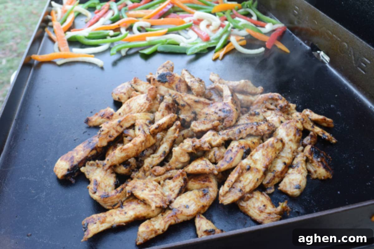 From Novice to Griddle Guru: 10 Hard-Earned Lessons After 3 Years on the Blackstone 6 Close up of perfectly cooked chicken on the Blackstone griddle, with vibrant, fresh vegetables softening in the background.