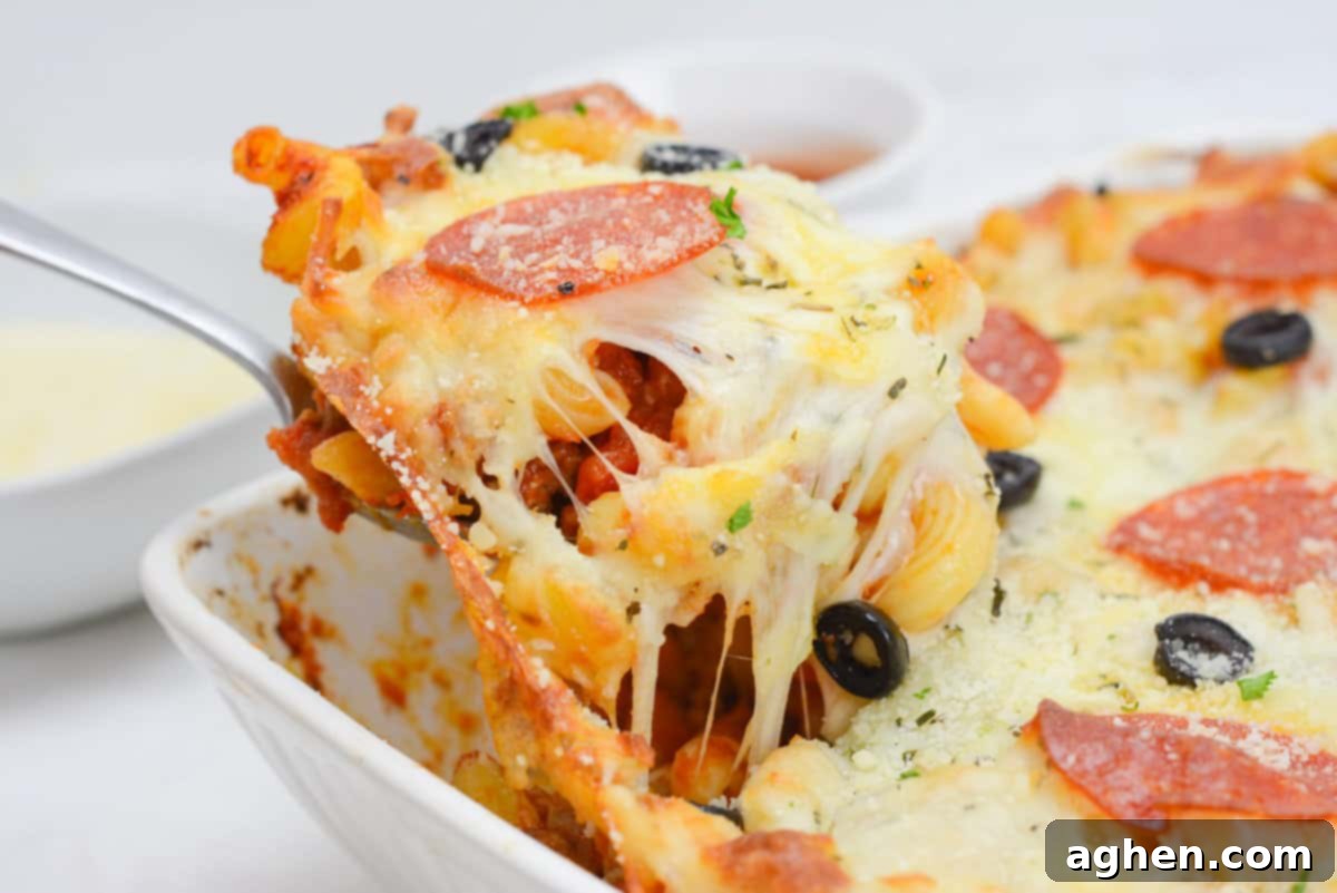 A side-view scoop of the baked casserole coming out of the dish with gooey cheese