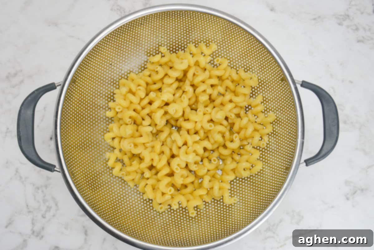 A large silver colander filled with drained cooked pasta 