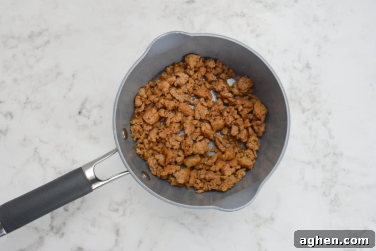 A small saucepan is filled with browned and crumbled turkey Italian sausage 