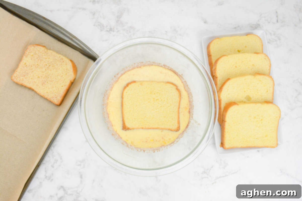Unlock Legendary Blackstone French Toast with 7 Easy Steps 6 A slice of bread is placed into a large mixing bowl filled with the custard mixture. A slice of dipped bread sits to the left while four slices of undipped bread are placed to the right.
