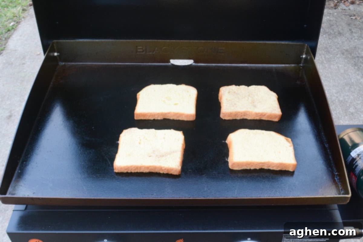 Unlock Legendary Blackstone French Toast with 7 Easy Steps 8 A close up of the Blackstone with four slices of dipped French toast