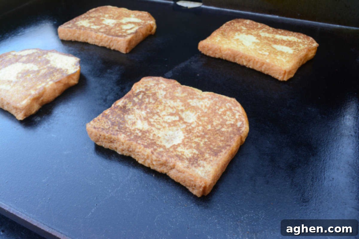 Unlock Legendary Blackstone French Toast with 7 Easy Steps 9 A close up of a golden brown slice of French toast on the Blackstone