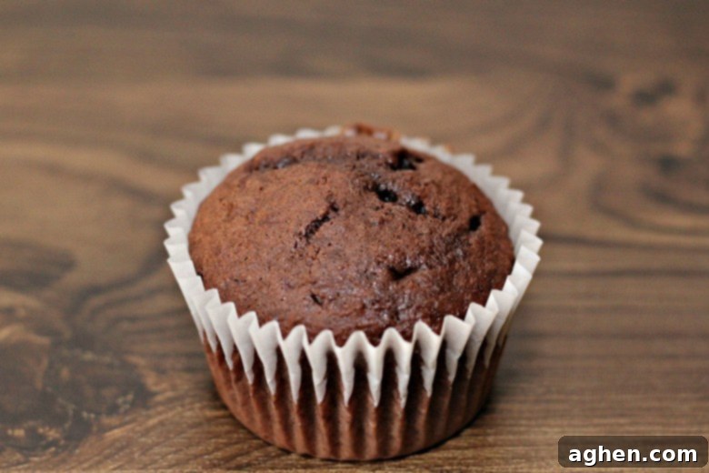 Devil's food chocolate cupcake batter in white liner, ready for baking.