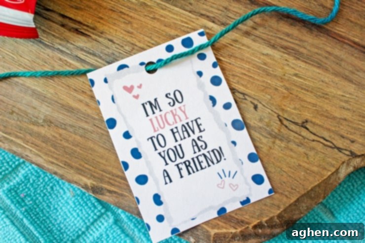 Gift tag with a hole punched in top and a green piece of thread attached.