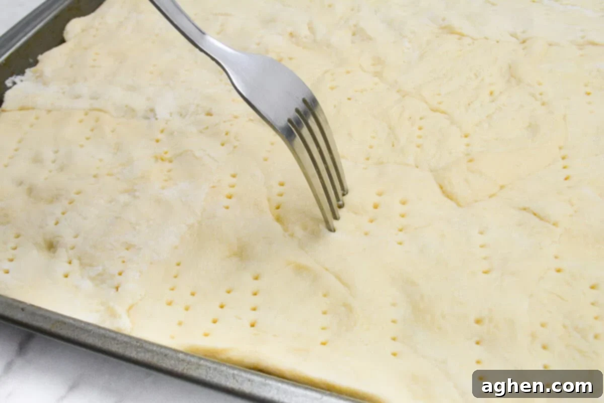 Close up of a fork docking the dough 