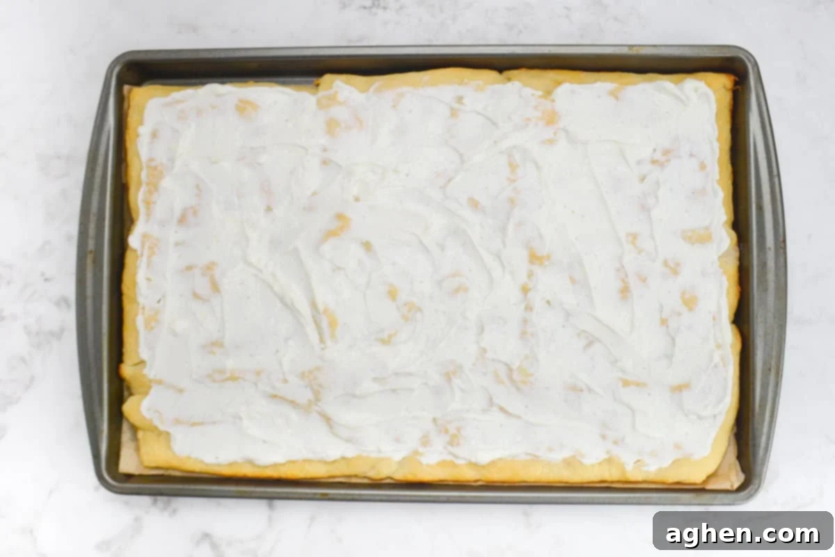 A baking sheet with the baked dough and a layer of cottage cheese ranch spread 
