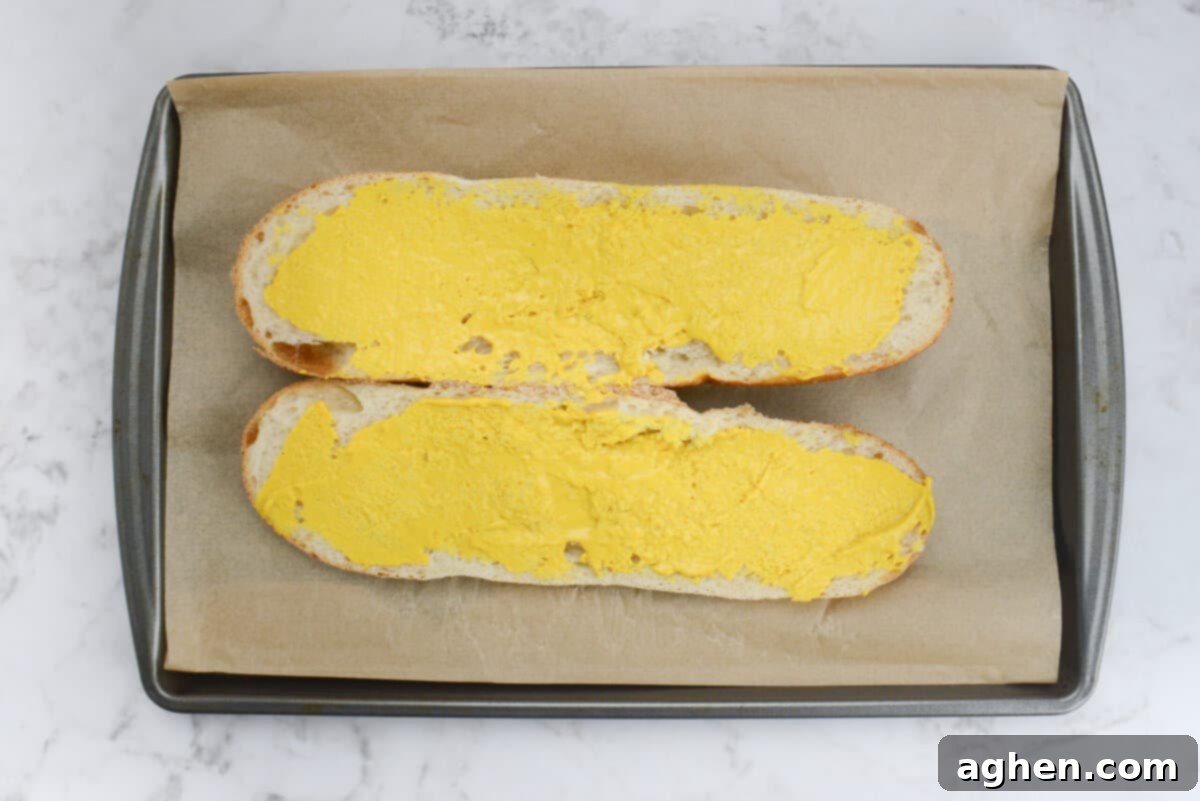 Öğle Yemeğiniz Asla Aynı Olmayacak: Blackstone Küba Sandviçi 5 Sliced French bread on parchment paper with mustard generously spread on both inner sides.