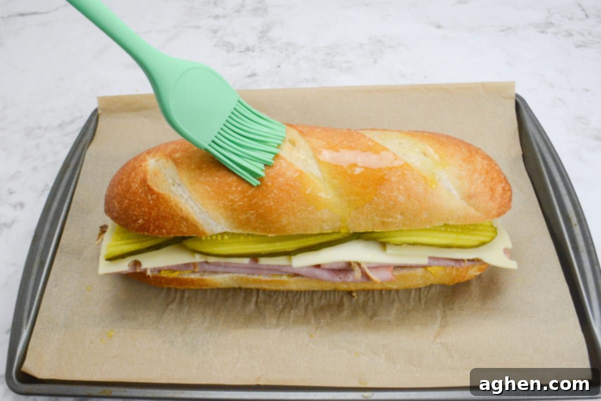 Öğle Yemeğiniz Asla Aynı Olmayacak: Blackstone Küba Sandviçi 9 Closed Blackstone Cuban Sandwich with olive oil being brushed on its exterior.