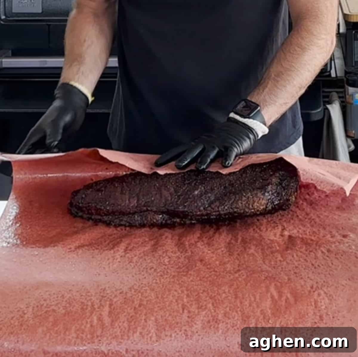 Traeger Brisket The Ultimate Guide To Perfection 7 Brisket being snugly wrapped in pink butcher paper on a cutting board, prepared for the next stage of cooking
