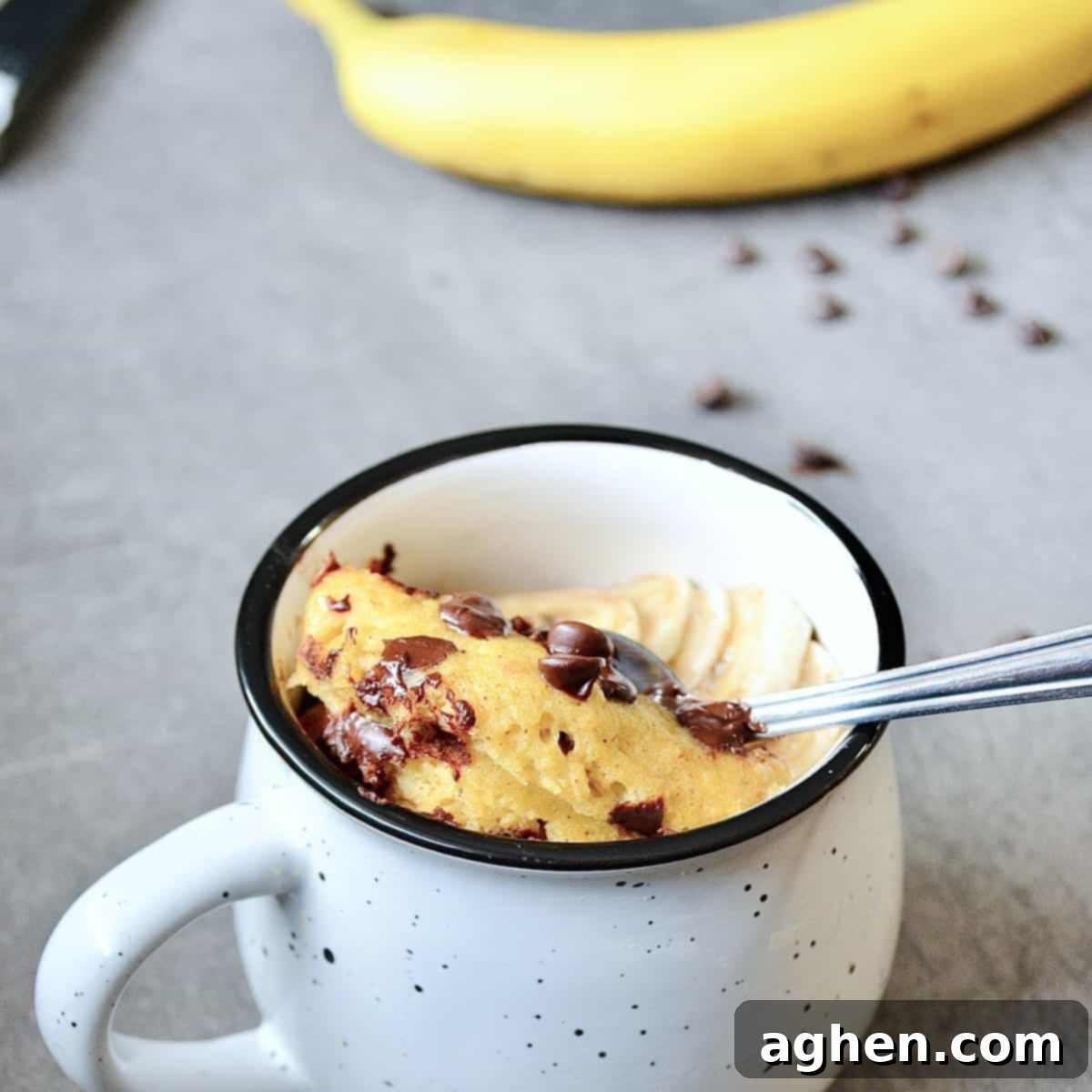 Easy Weight Watchers Banana Chocolate Chip Mug Cake 5 Banana chocolate chip dessert in a mug with a spoon, ready to eat