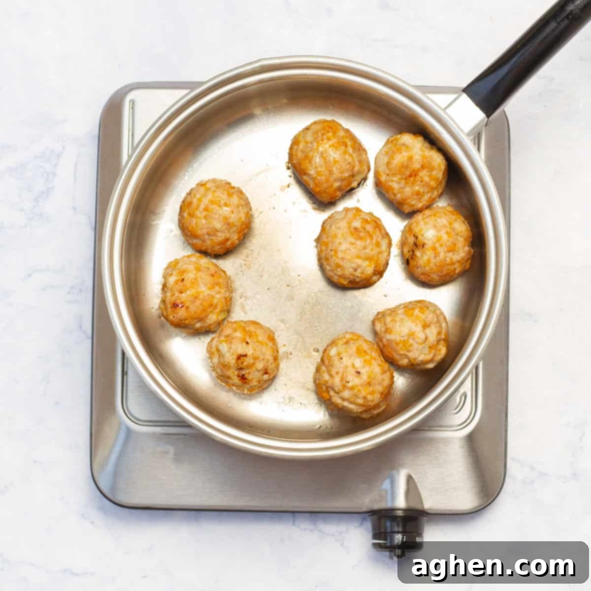 Whip Up Weight Watchers Chicken Meatballs in Just 30 Minutes 6 Pesto Chicken Meatballs cooking in cooking pan over heat