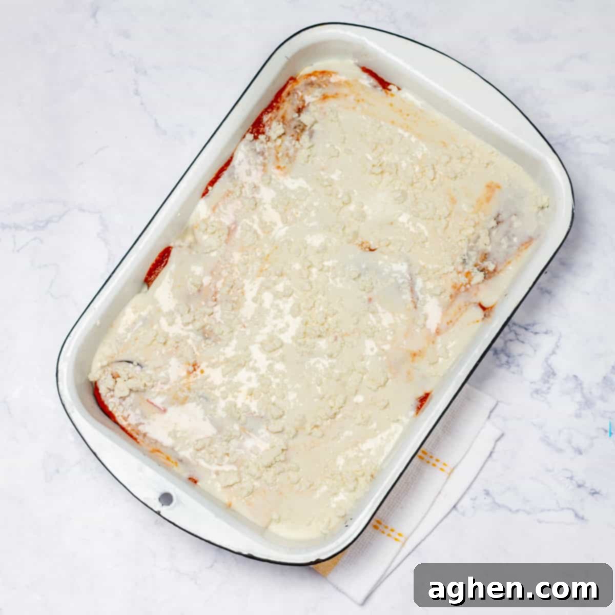 In a backing tray with eggplant slice a layer of bechamel sauce and a sprinkle of Parmesan cheese on top