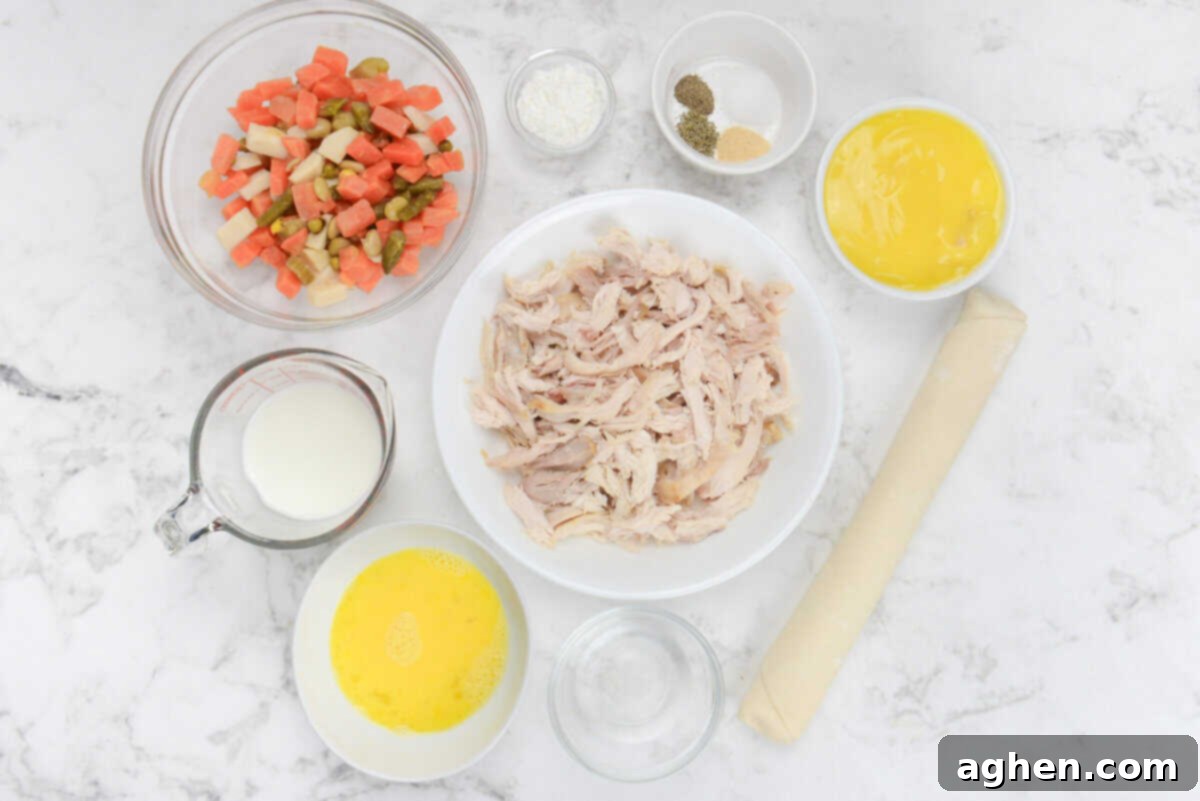 All the ingredients needed for the chicken pot pie recipe, neatly arranged in various sized bowls on a rustic surface.