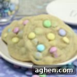 Large cookies with pastel M&Ms, served on a white plate.