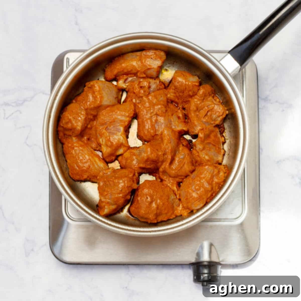 marinated chicken pieces added to the skillet and cook