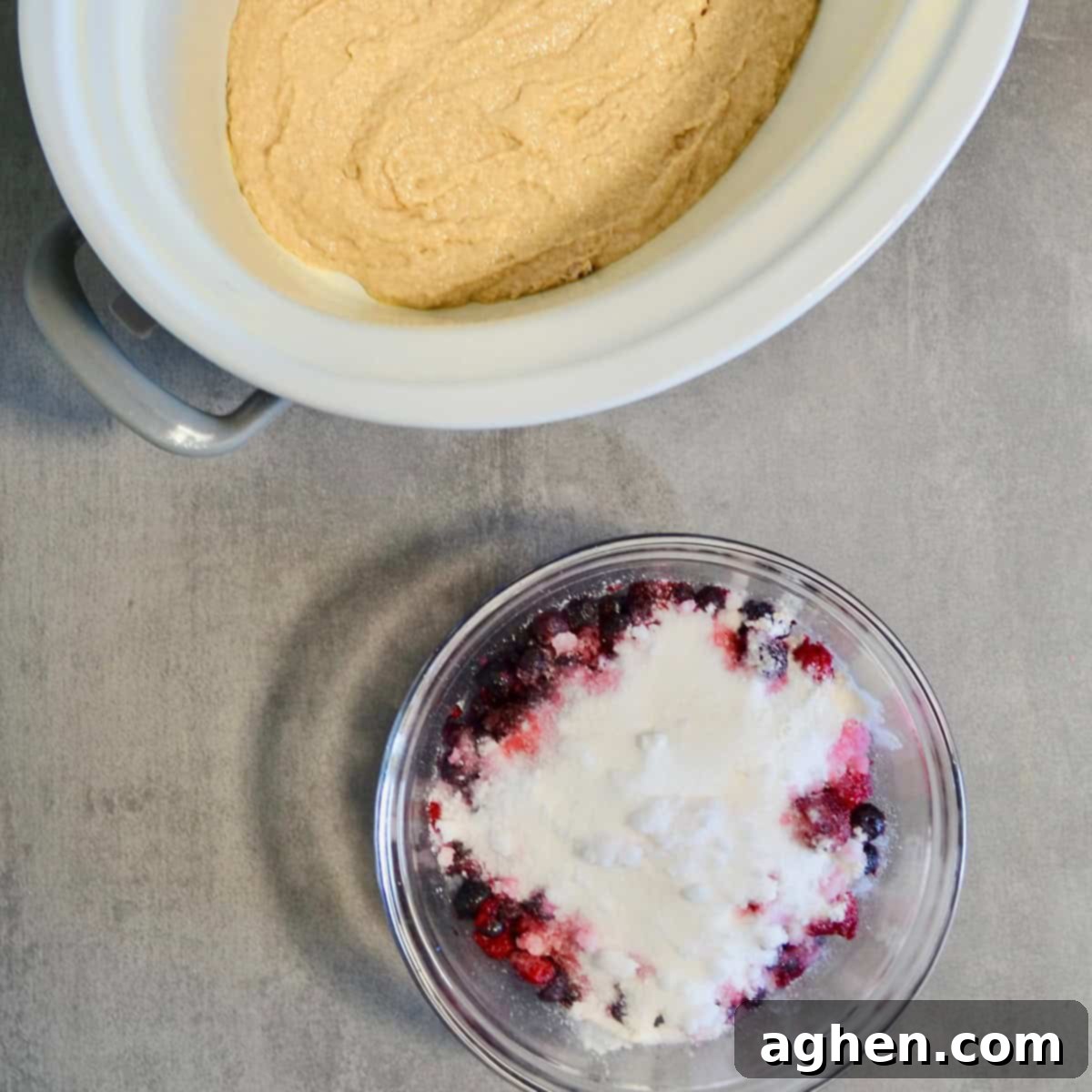 Smoothly spread cobbler batter filling the bottom of a slow cooker pot.