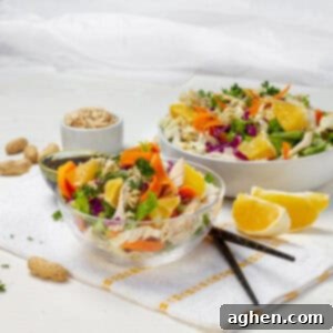 Chinese Chicken Salad served in two bowls, garnished with peanuts and fresh herbs.
