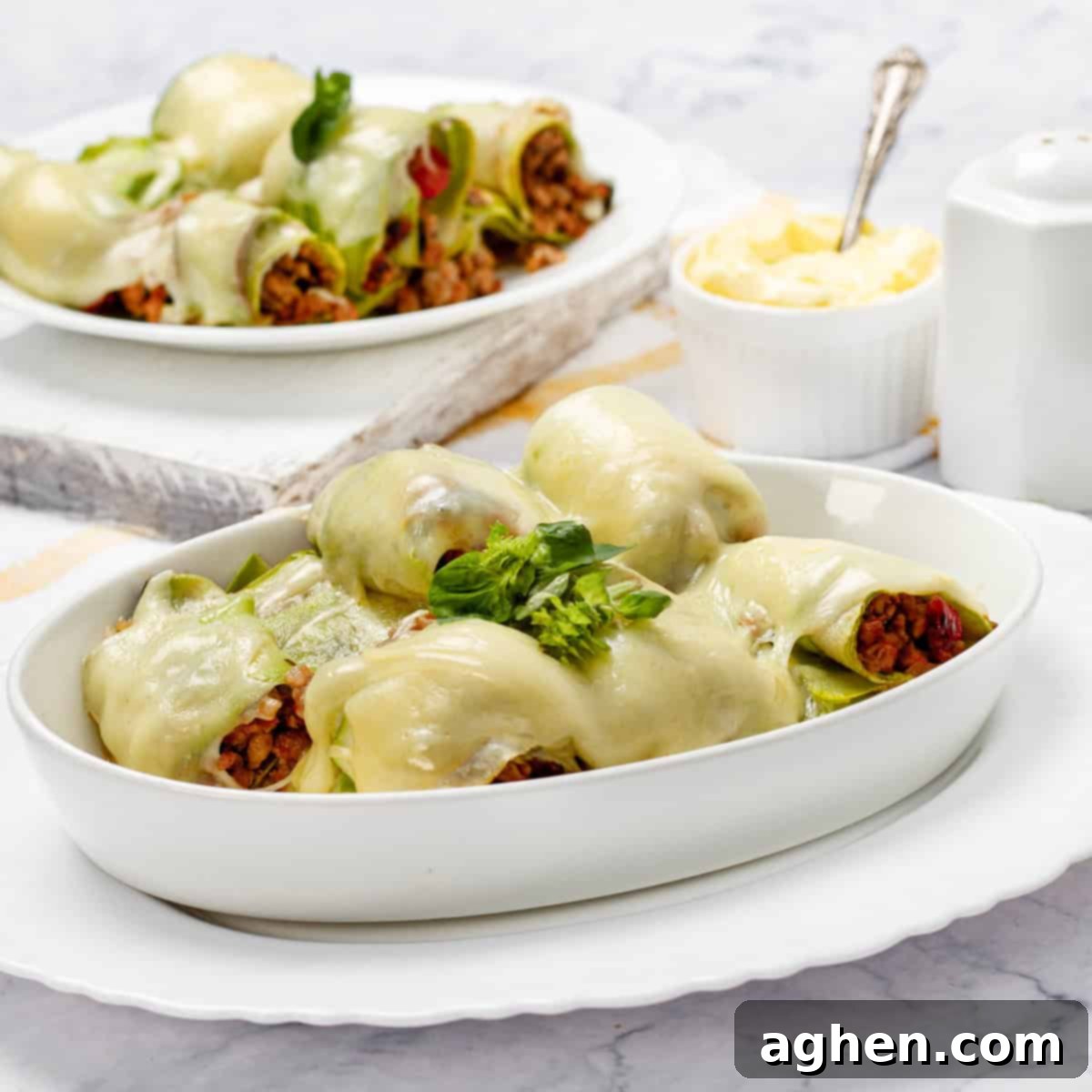 Two plates of Zucchini Cannelloni with wooden forks, showcasing a healthy and delicious meal.