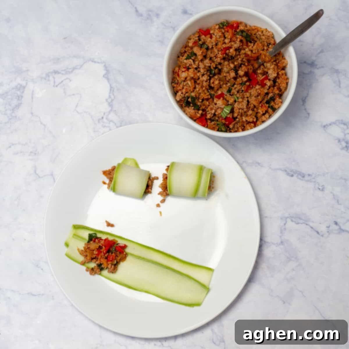 Thin zucchini slices laid out with a bowl of Napolitan sauce ready for cannelloni assembly.
