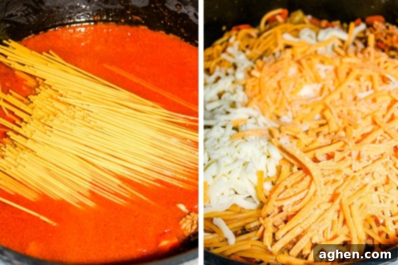 Cooked spaghetti and shredded cheese being added to a pot of taco meat and sauce