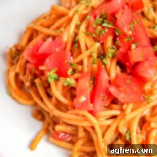 Taco spaghetti topped with tomatoes and cilantro