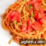 Taco spaghetti topped with tomatoes and cilantro