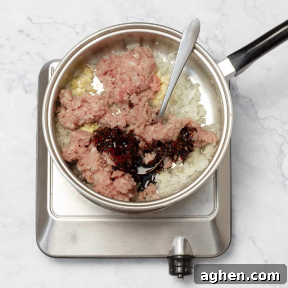 Weight Watchers Domuz Bulgogisi Dolu Dolu Lezzet 5 Ground pork cooking in a skillet with soy sauce, being broken apart with a spoon