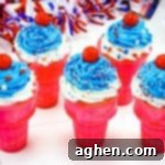 Close-up of a festive 4th of July ice cream cone cupcake, featuring white and blue icing and patriotic sprinkles, ready for sharing on social media.
