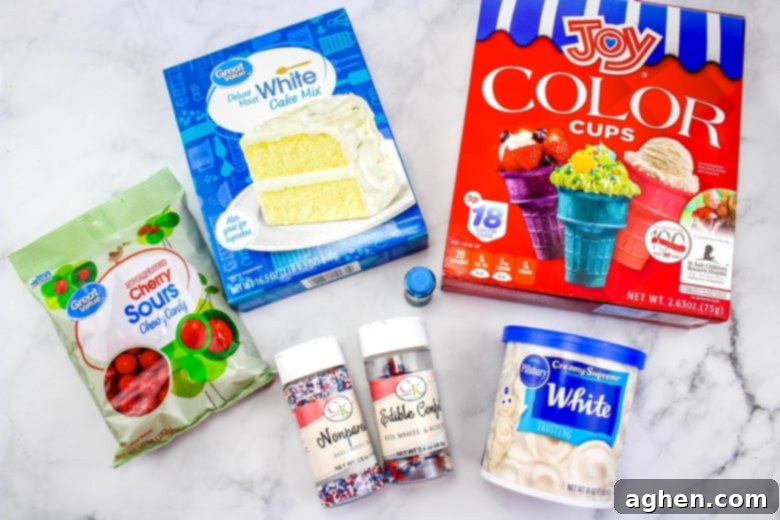 Ingredients for 4th of July Ice Cream Cone Cupcakes: red Joy brand cones, white cake mix, white frosting, sour cherry candies, blue food coloring, and patriotic sprinkles laid out on a table.