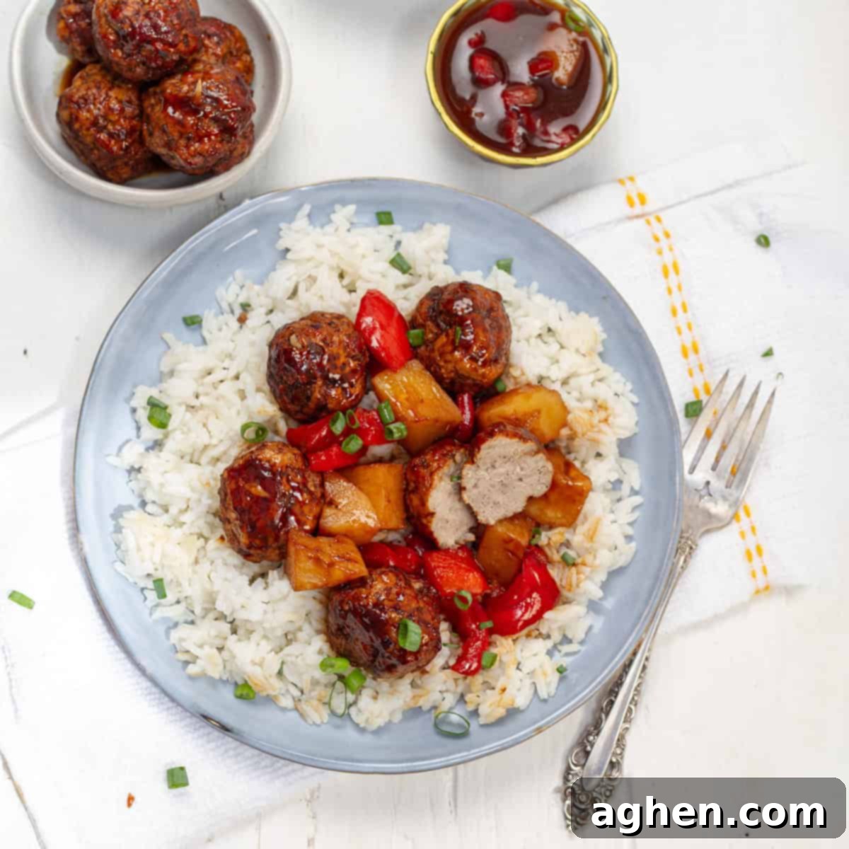 Hawaiian Pork Meatballs served with rice and garnished with green onions