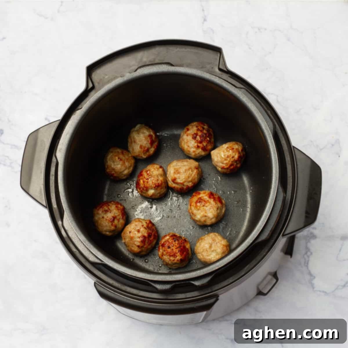 Pork meatballs browning in an Instant Pot on Sauté mode