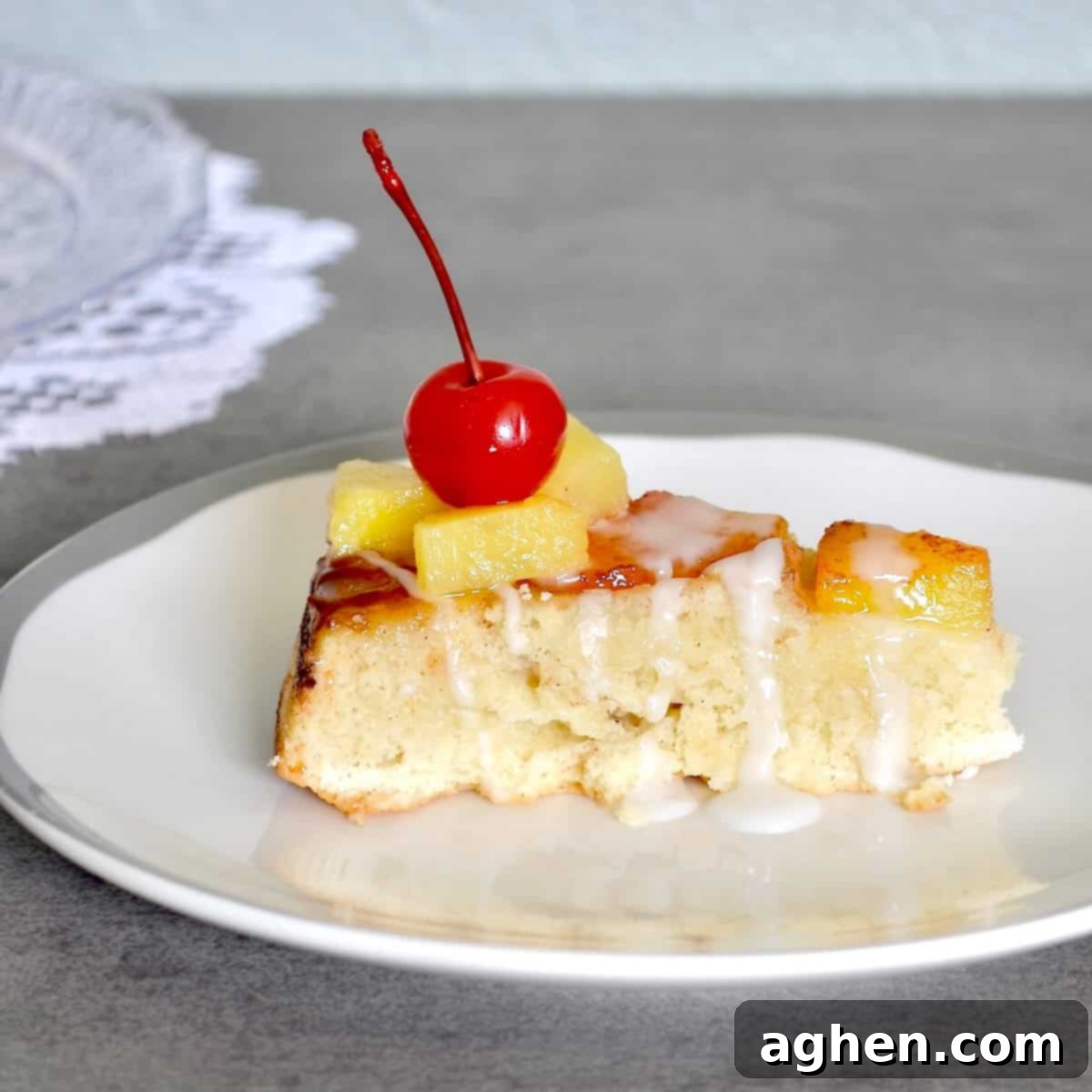 Slice of Weight Watchers pineapple upside-down cake with pineapples and cherries