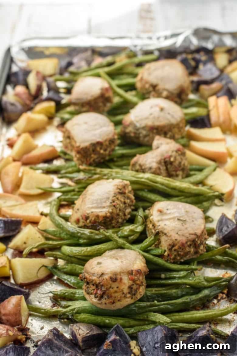 Potatoes, green beans, apples, and pork tenderloin medallions on sheet pan