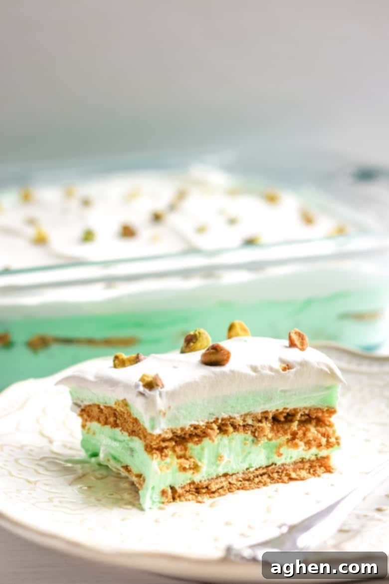 Pistachio Pudding Dessert on plate with 9x13 cake pan behind.