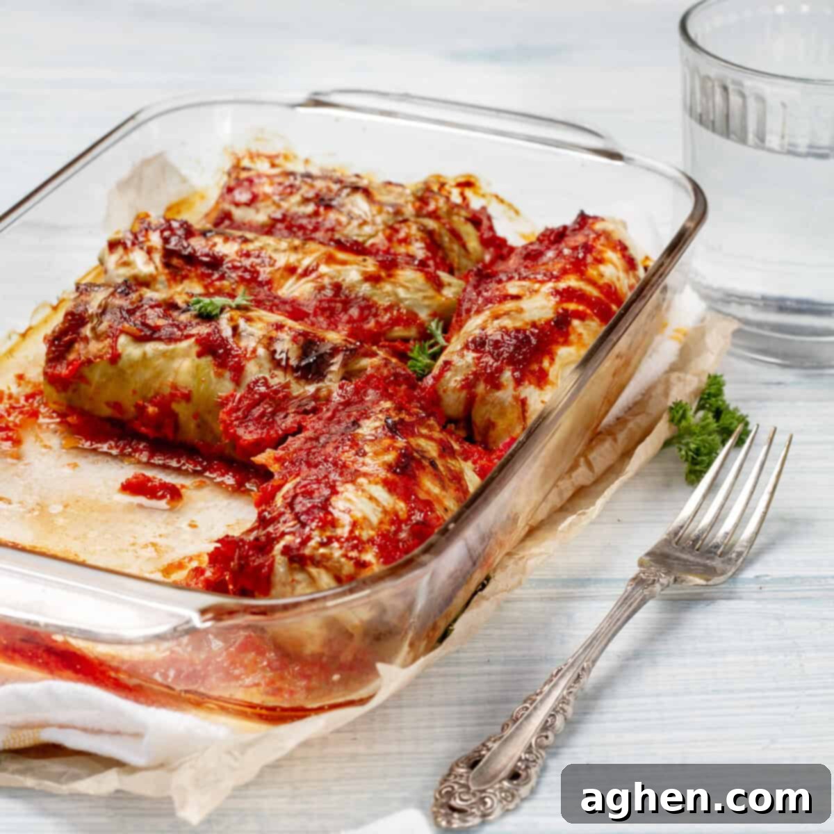 A delectable serving of freshly baked Pork Cabbage Rolls in a simmering marinara sauce, elegantly presented on a plate and ready to be savored immediately.