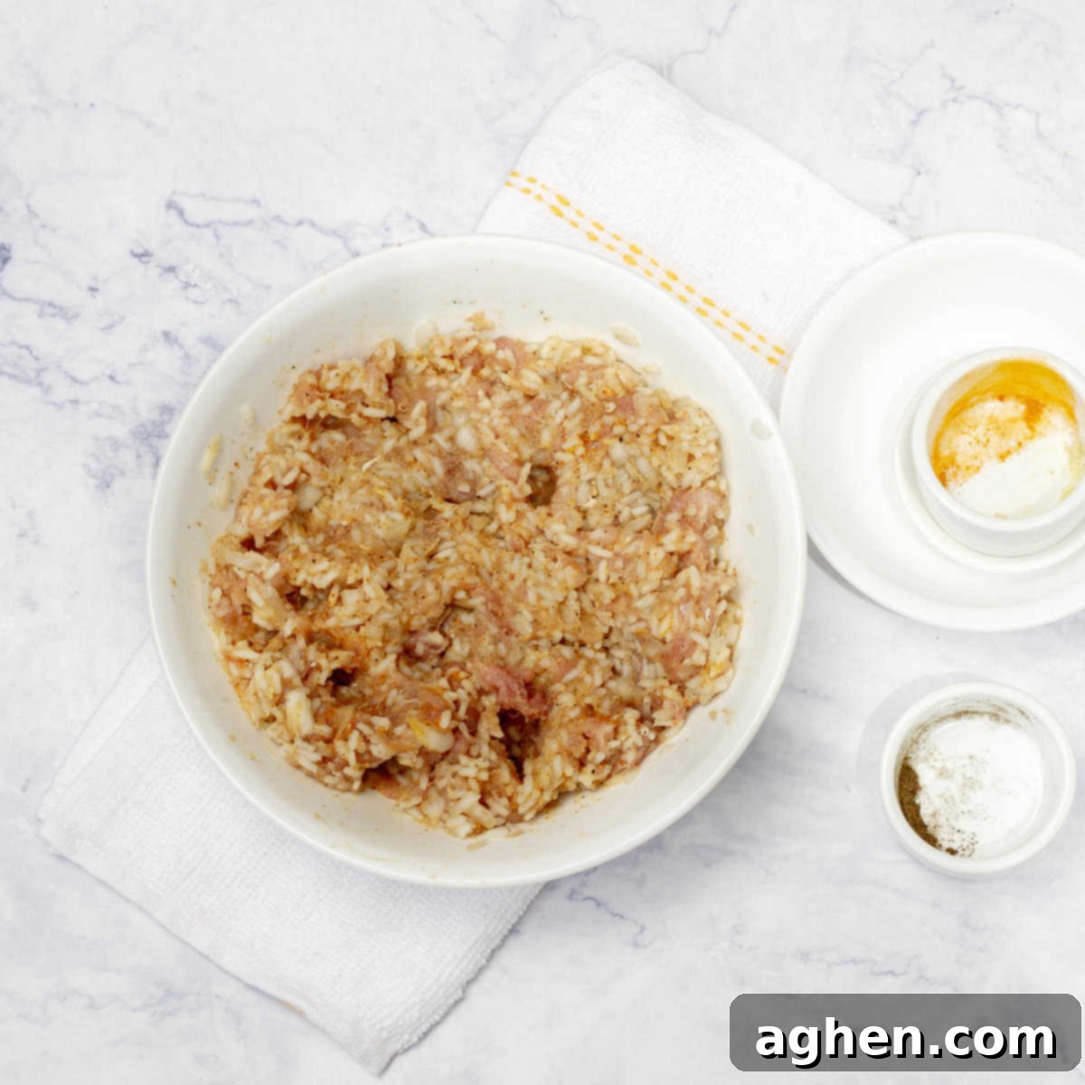 A close-up view of the ground pork, rice, and spice filling being thoroughly mixed by hand in a large bowl, ensuring all ingredients are evenly distributed for a consistent flavor.