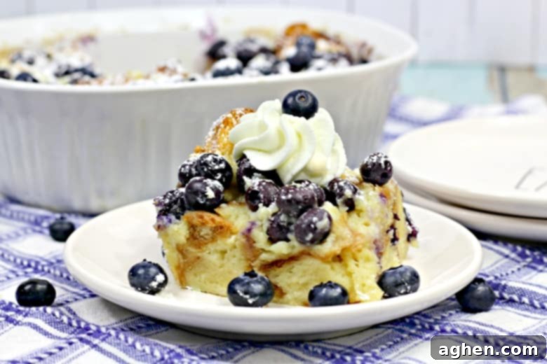 A delectable slice of blueberry breakfast bake, generously garnished with fresh blueberries and a swirl of fluffy whipped cream, inviting you to indulge in its rich flavors.