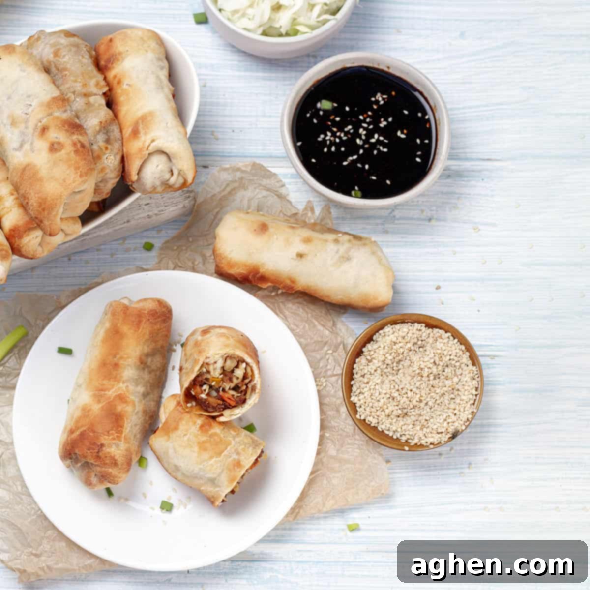 Ditch Takeout for These Weight Watchers Pork Egg Rolls 2 Crispy Air Fryer Pork Egg Rolls served beautifully on a dish with dipping sauce, alongside a backing tray filled with more freshly cooked egg rolls.