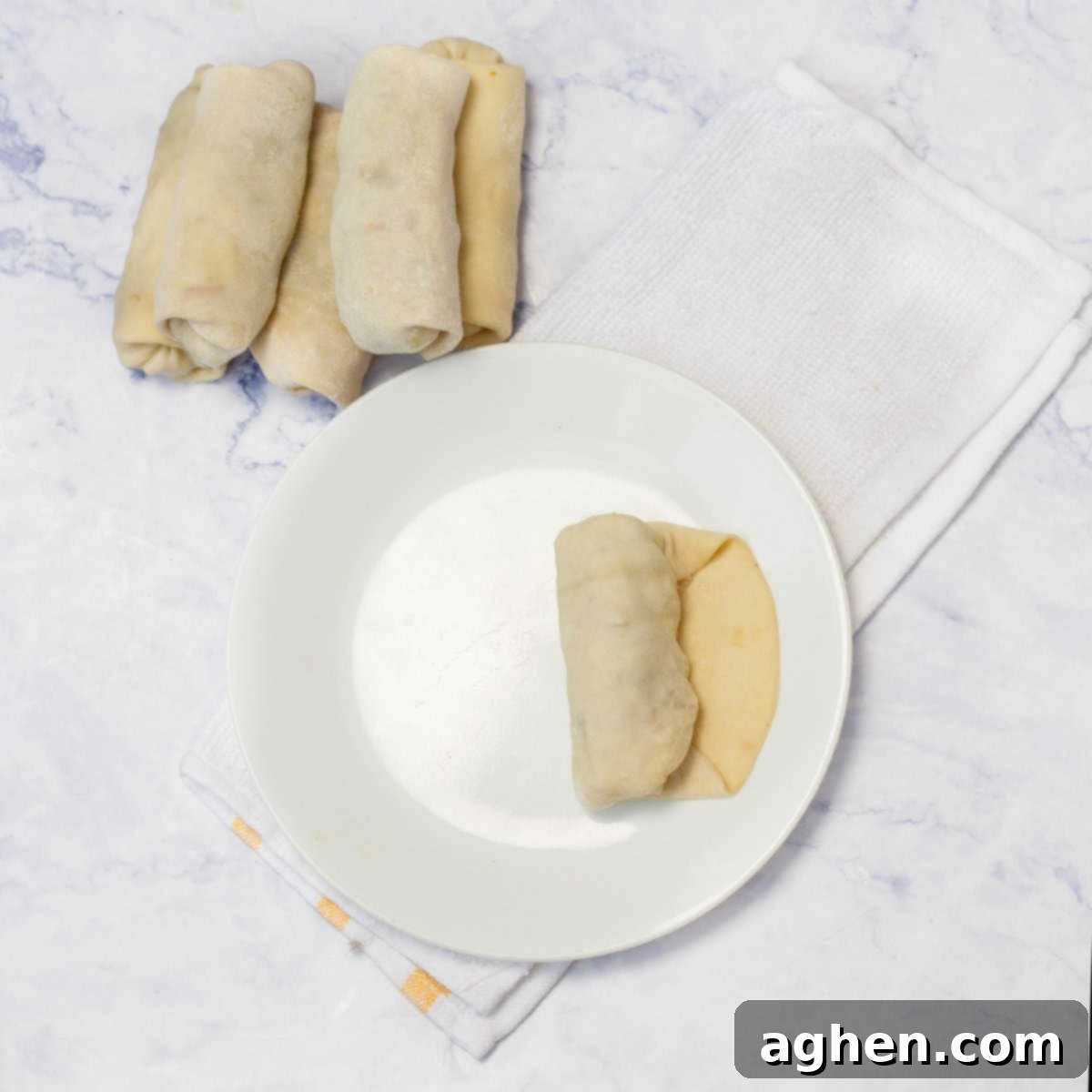 Ditch Takeout for These Weight Watchers Pork Egg Rolls 7 A step-by-step image showing the side corners of the egg roll wrapper folded inward towards the center, creating a neat, compact shape before the final roll.