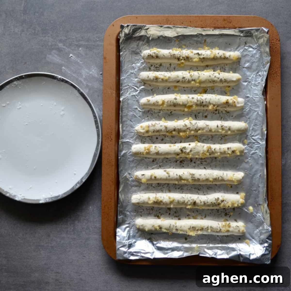 Unbaked Weight Watchers garlic breadsticks, perfectly shaped and ready for the oven