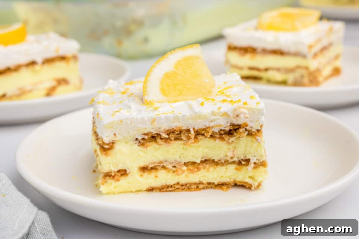 Slice of icebox lemon cake with layers of graham crackers, lemon pudding, and cool whip. 
